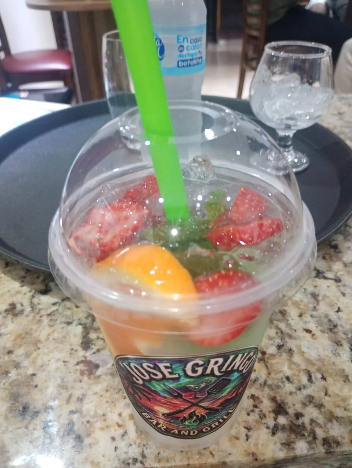 A strawberry and orange drink in a cup printed with the Jose Gringo emblem